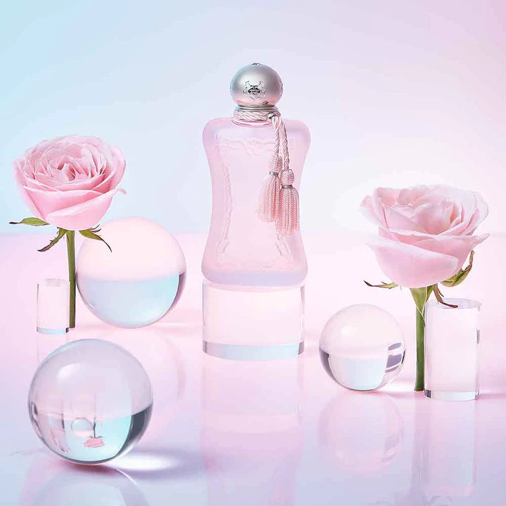 Parfums De Marly Delina La Rosee perfume bottle with pink roses and glass spheres on light background
