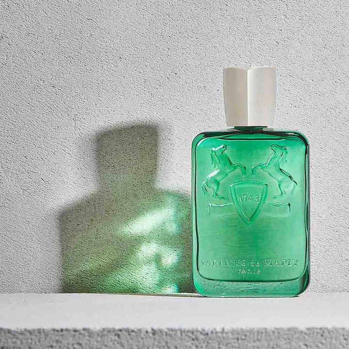 Parfums De Marly Greenley 125ml green glass perfume bottle with white cap casting shadow on gray background