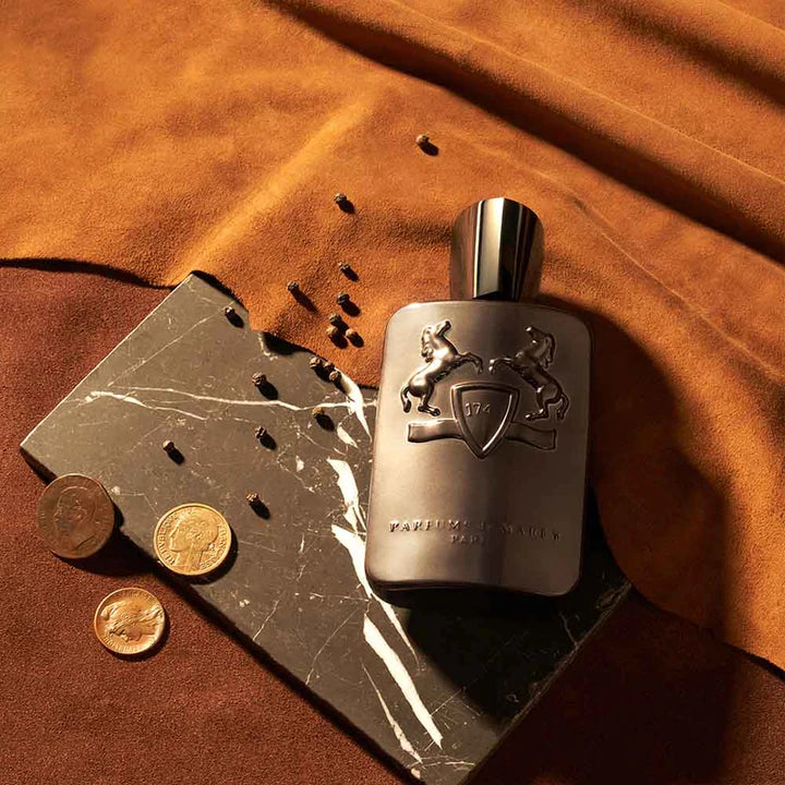 Parfums de Marly Herod Eau de Parfum bottle with embossed design on black marble and brown fabric background