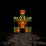 Puzzle Purgatory perfume bottle with vibrant geometric design on black background