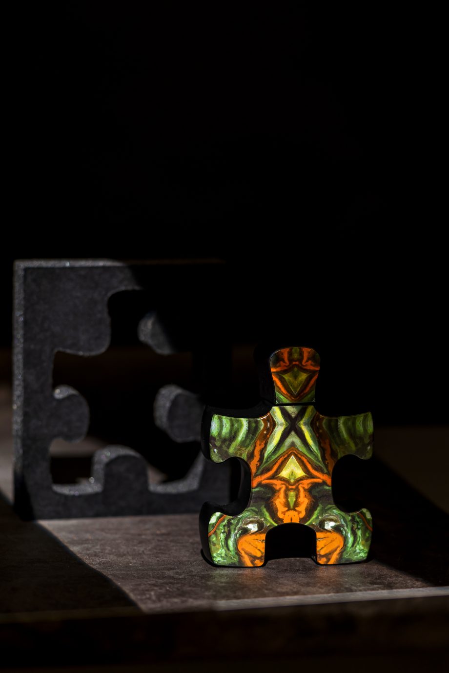 Puzzle Purgatory perfume with colorful puzzle piece shaped bottle and dark background
