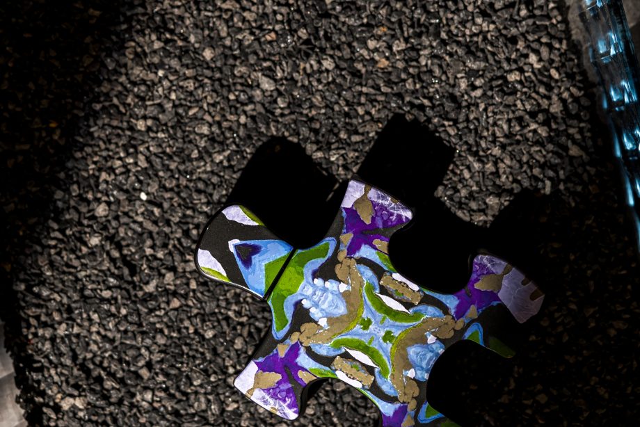 Colorful puzzle-shaped bottle of Puzzle Sarcastic perfume on dark textured surface
