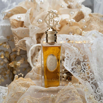 Royal Glory Mystery Eau de Parfum bottle with gold cap and intricate packaging lace and pearls background