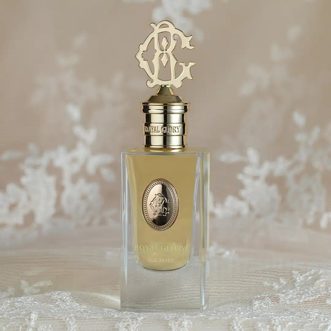 ROYAL GLORY Oud Zayed perfume bottle with gold cap and clear glass on lace background