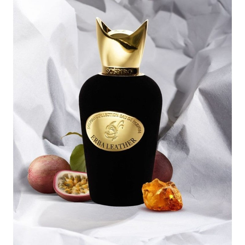 SOSPIRO Erba Leather Eau de Parfum black bottle with gold cap surrounded by citrus and floral ingredients