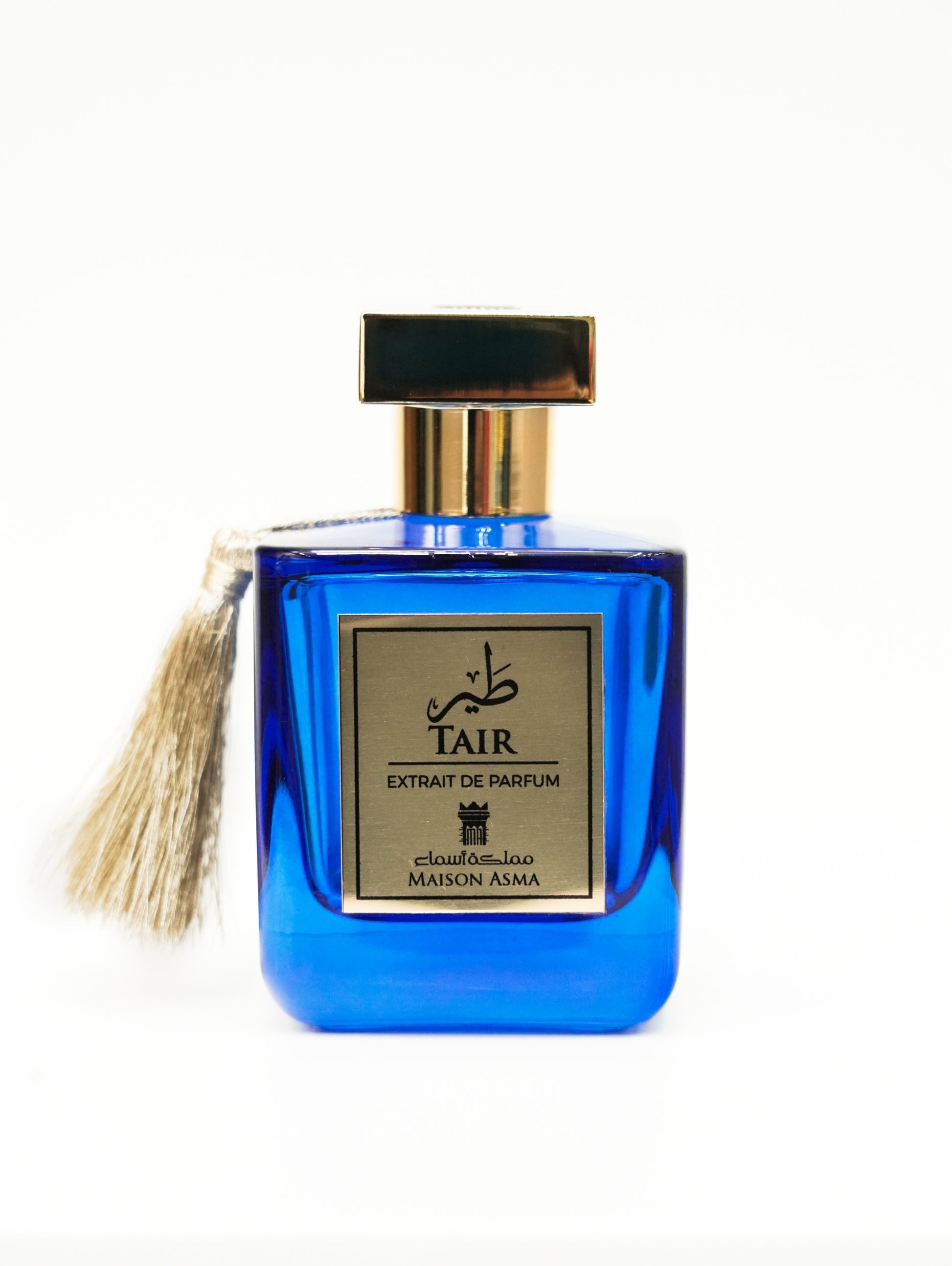 Maison Asma Tair niche fragrance Dubai in a blue glass perfume bottle with gold cap and tassel