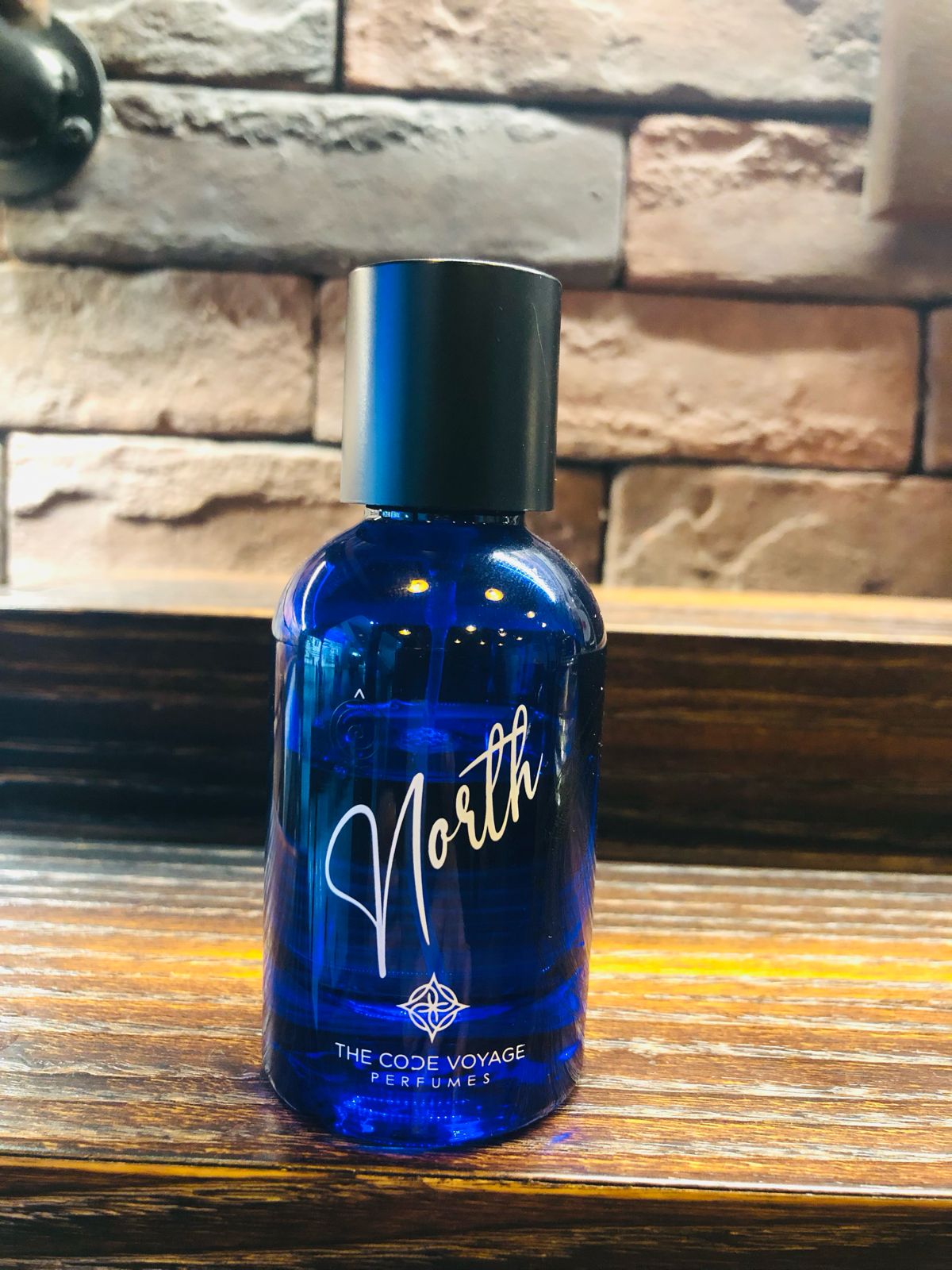 NORTH perfume by THE CODE VOYAGE in a blue bottle with a sleek design and black cap