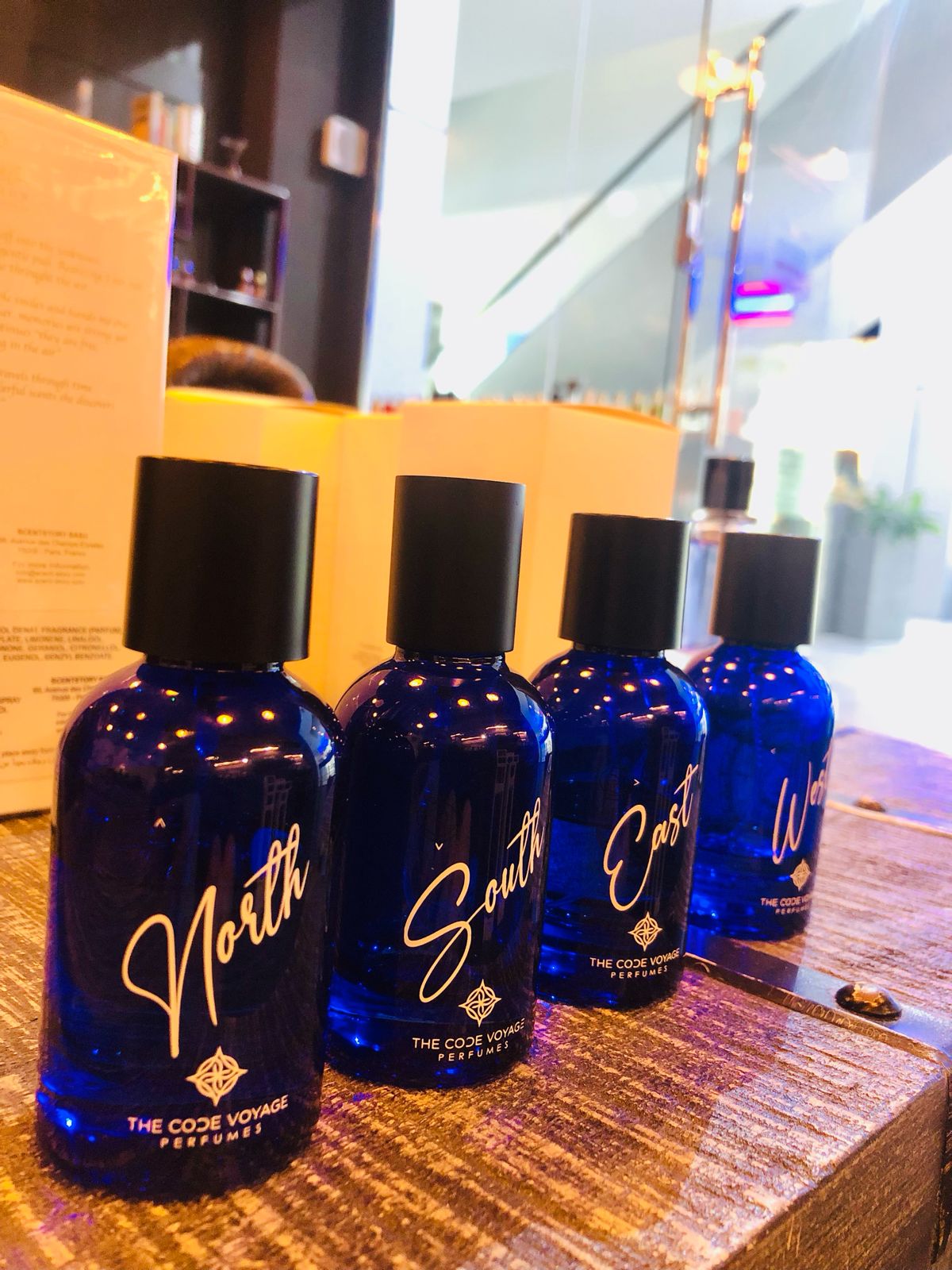 NORTH perfume by THE CODE VOYAGE in a blue bottle on display with other fragrance bottles