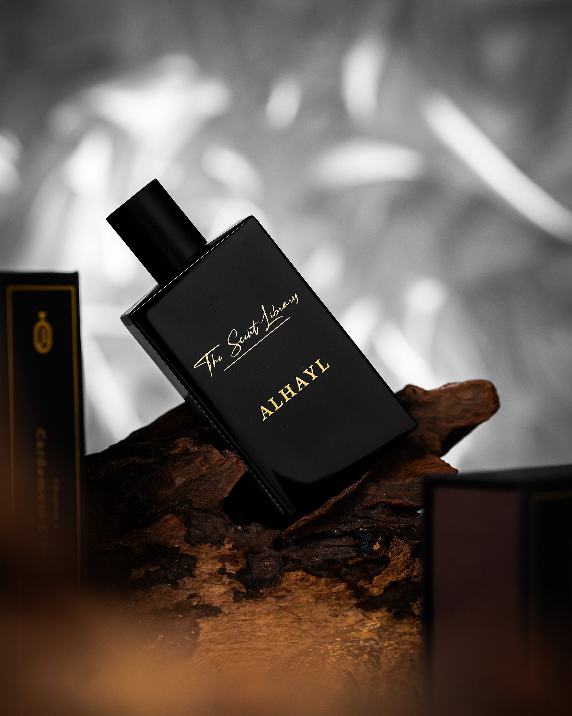 ALHAYL eau de parfum by The Scent Library shown on a piece of agarwood in a moody lifestyle setting