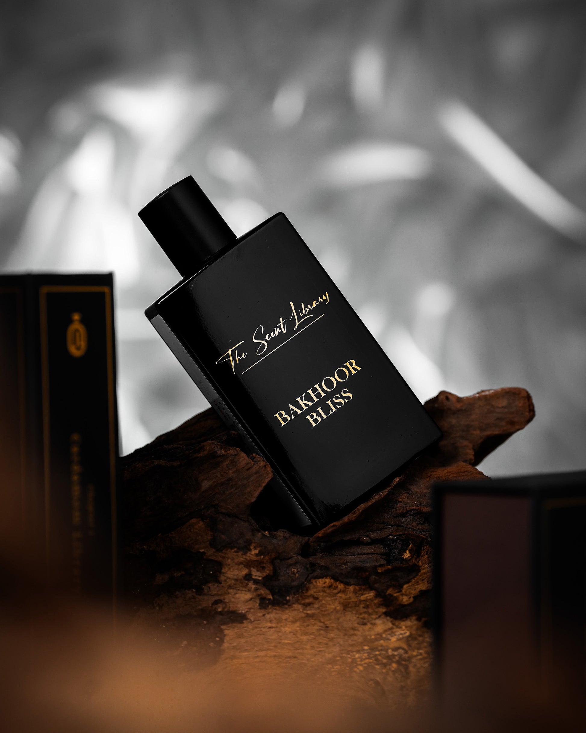 Bakhoor Bliss eau de parfum by The Scent Library shown on agarwood in a moody lifestyle setting