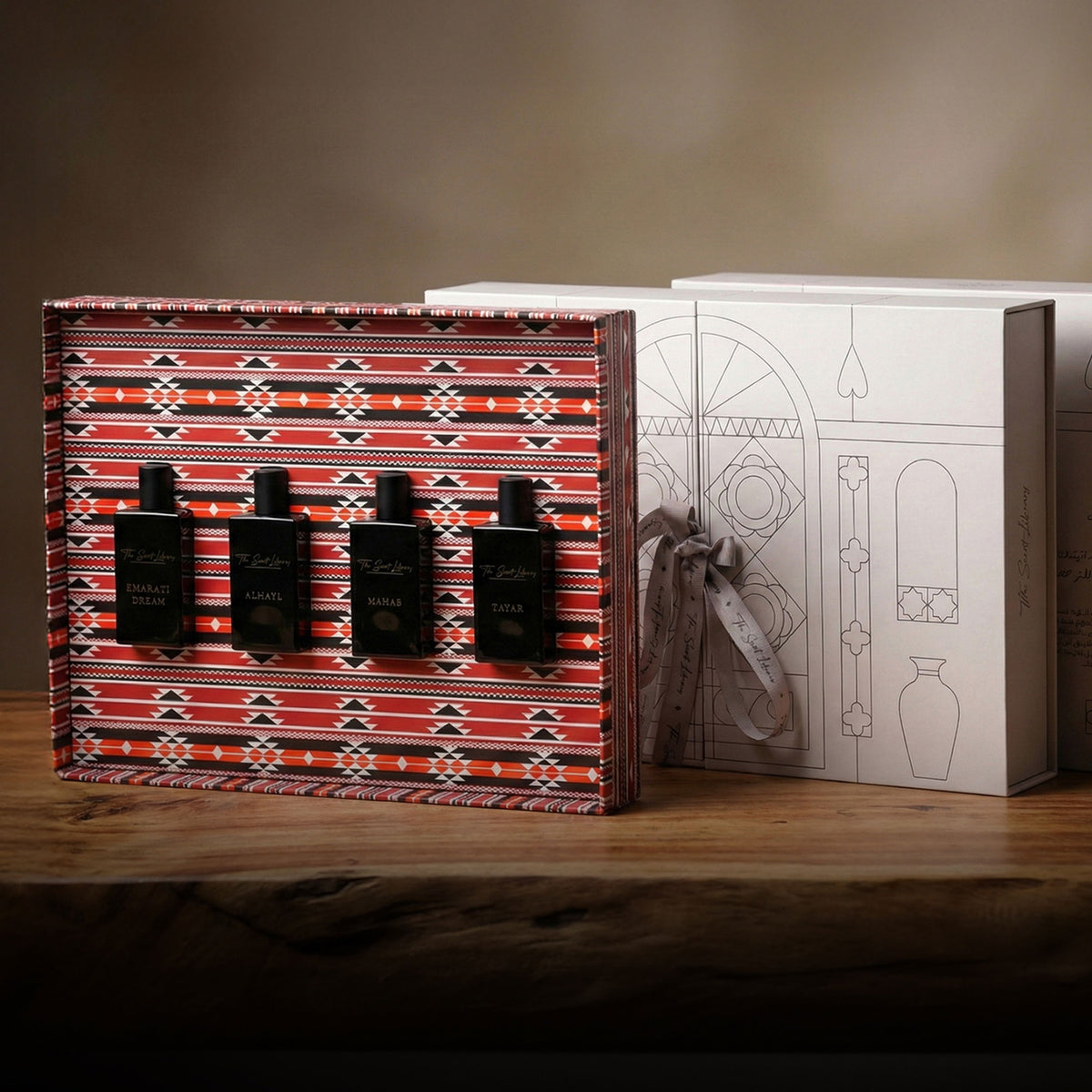 The Private Collection by Baytak, four black perfume bottles in a red Sadu-patterned gift box beside a white presentation box, by The Scent Library