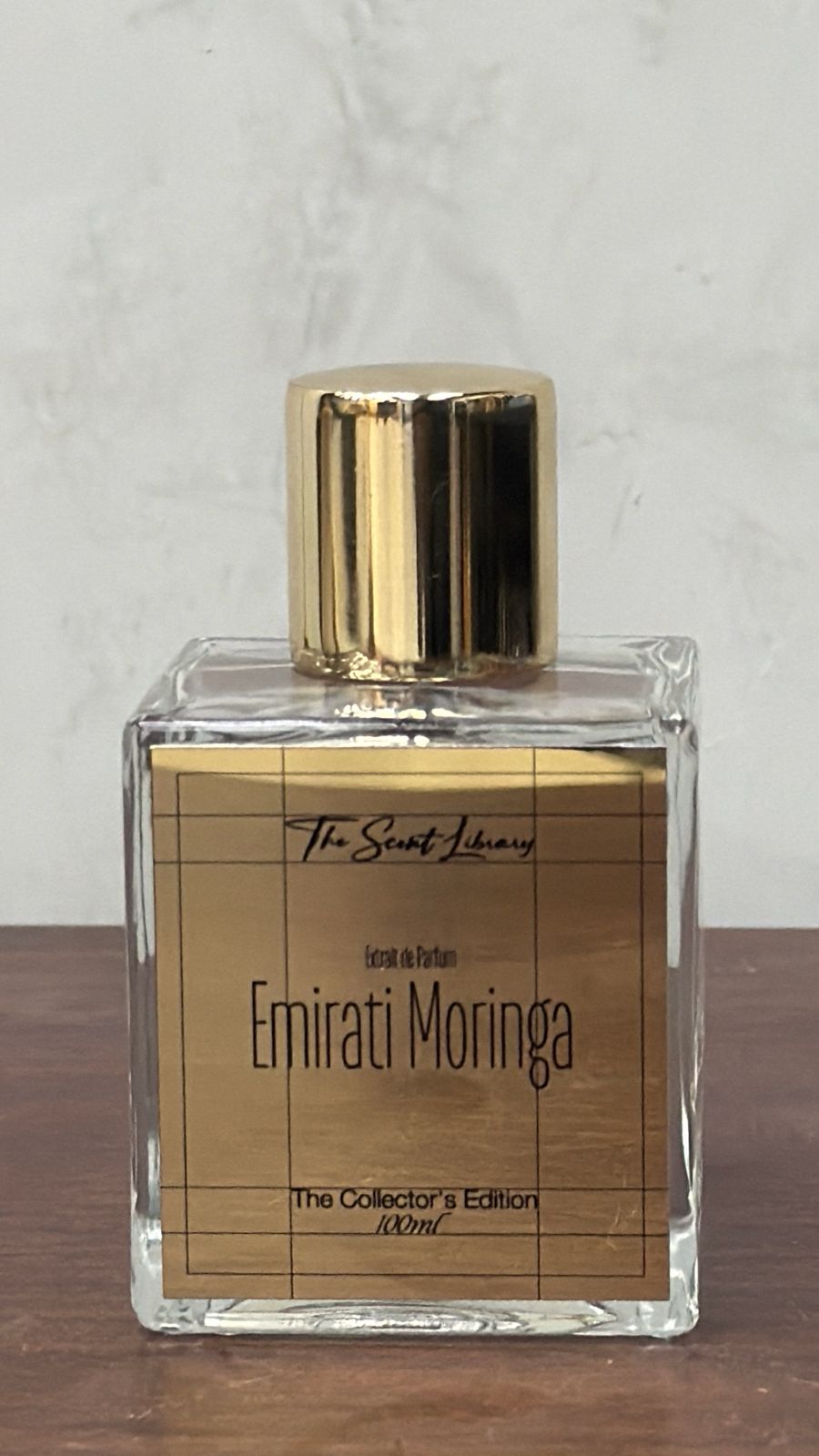 The Scent Library Emirati Moringa perfume in a clear glass bottle with gold accents
