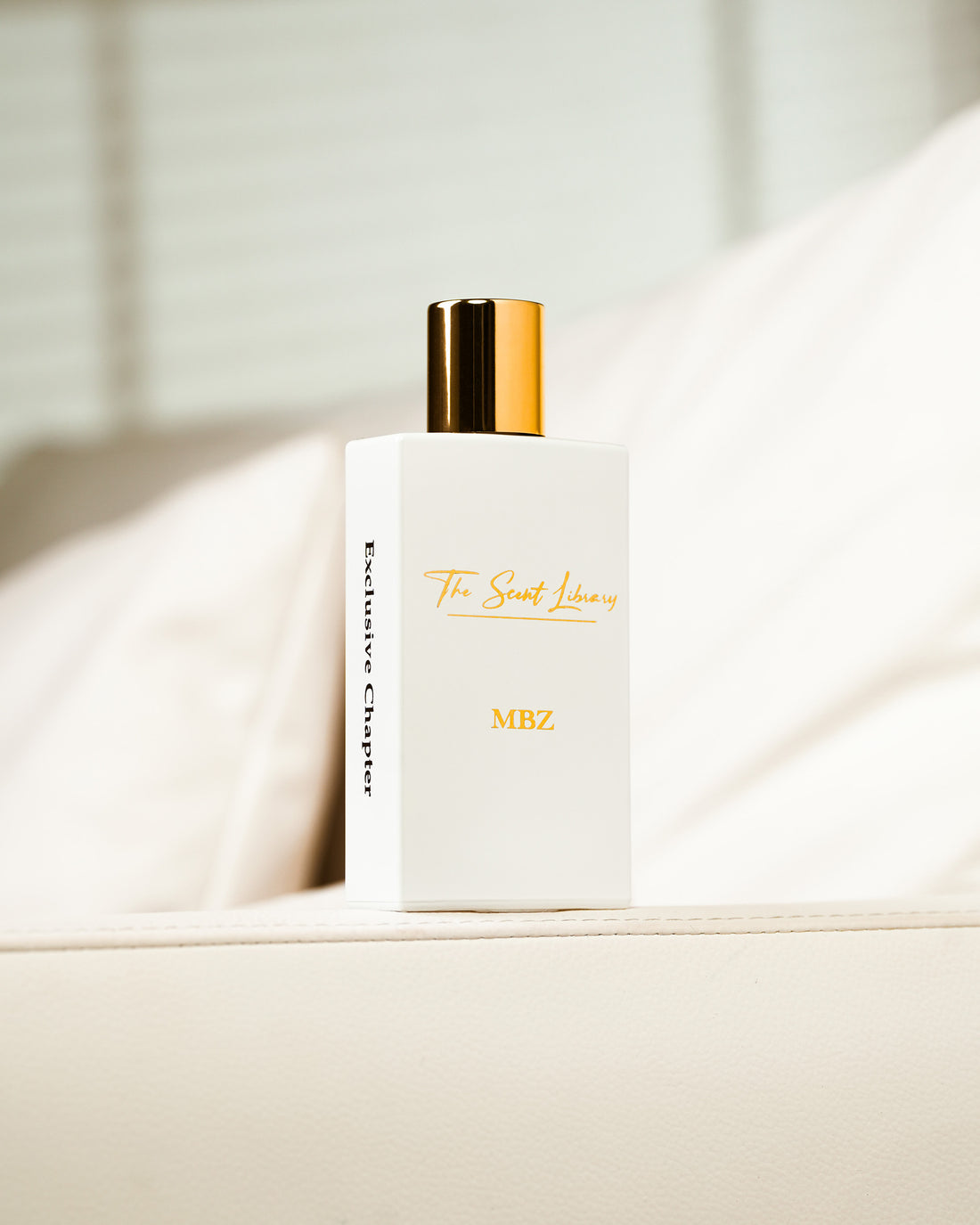 MBZ eau de parfum by The Scent Library, a white rectangular bottle with a gold cap beside its white book-style presentation box