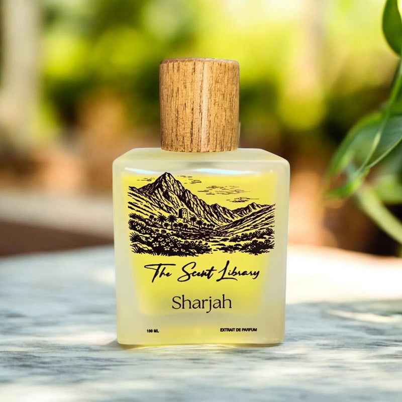 Sharjah extrait de parfum by The Scent Library, a frosted glass bottle with a wooden cap and an illustrated label of a mountain valley and fort